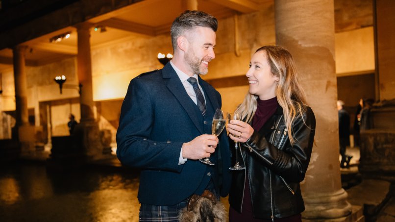 Couple enjoy drinks beside the Great Bath at New Year